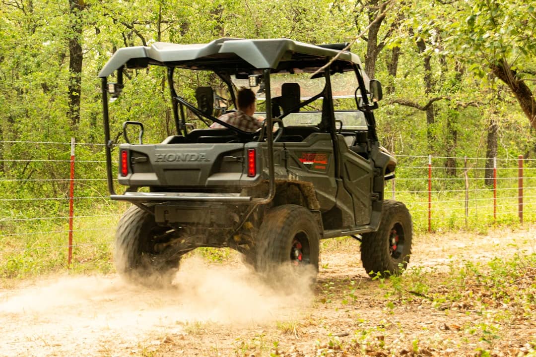 a man driving a four - wheeler on a dirt road