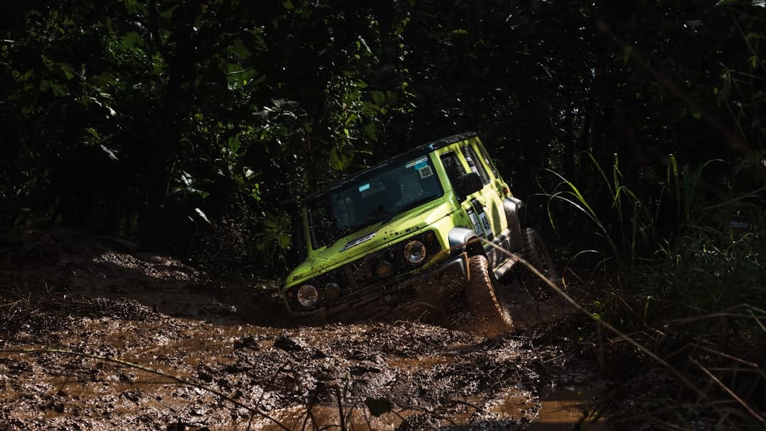 A lime green all-terrain vehicle stuck in mud